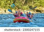 team of cheerful travelers are rafting on a boat on a stormy river