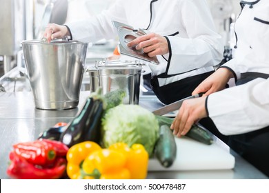 Team Of Chefs Preparing Food In Canteen Kitchen