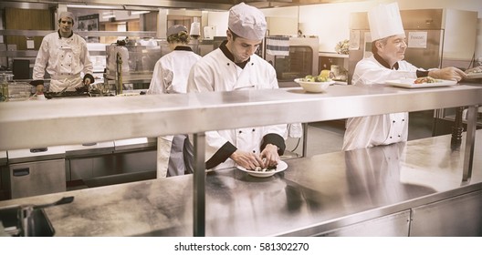 Team Of Chefs Working In Professional Kitchen