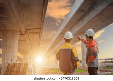 A team of civil engineers collaborates with architects to review designs and oversee the building of a new highway. At the site of highway construction, a male civil engineer and a female architect - Powered by Shutterstock