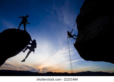 Team Of Climbers Reaching The Summit Of A Rock Pinnacle In The Sierra Nevada Mountains, California.