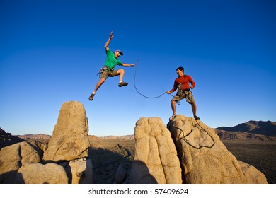 Team Of Climbers Reaching  The Summit Of A Rock Spire.