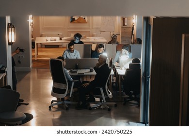 Team collaboration and discussion in modern office environment at night. - Powered by Shutterstock