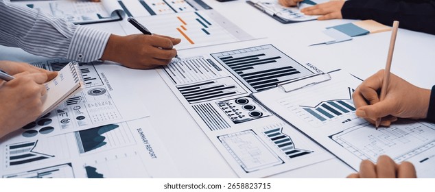 Team Collaboration in Office Analyzing Data and Creating Business Reports with Charts and Graphs on Table for Strategic Planning and Decision Making SACTR