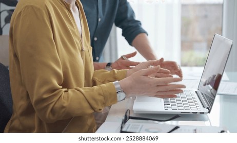 Team collaboration over financial reports. Business people, professionals analyzing financial charts and data on a desk while sitting near a laptop computer - Powered by Shutterstock