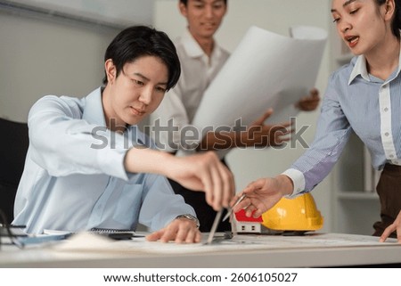 Team Collaboration and Planning. Professionals devising a construction project strategy together with blueprints in an office setting.