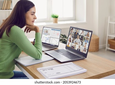 Team Of Colleagues Who Are Working From Home In Lockdown Create Online Network, Meet And Discuss Their Agenda. Young Woman Sitting At Desk And Looking At Laptop Screen During Sales Report Presentation