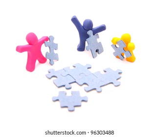 team of colorful plasticine people solving the puzzle together - teamwork concept - isolated on white - Powered by Shutterstock