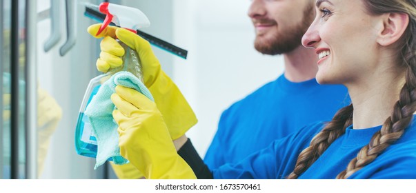 Team Of Commercial Cleaners Working In An Office Cleaning The Windows