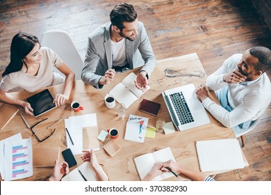 Team Communication. Top View Part Of Group Of Five People Discussing Something With Smile While Sitting At The Office Table