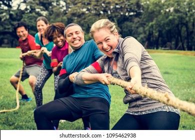 Team competing in tug of war - Shutterstock ID 1095462938