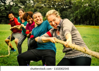 Team competing in tug of war - Shutterstock ID 1102002545