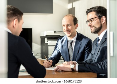 Team of confident successful business people reviewing and signing a contract to seal the deal at business meeting in modern corporate office. Business and entrepreneurship concept.