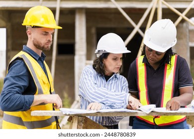 Team of construction contractor talking - discussing about the building plan together at construction site. Diverse ethnicity construction workers working together at construction site. - Powered by Shutterstock