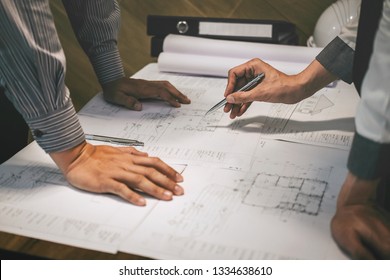 Team of construction engineering or architect partner discuss a blueprint while checking information on drawing and sketching meeting for architectural project with engineering equipment tool.