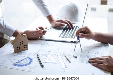 Team of construction engineering or architect partner discuss a blueprint while checking information on drawing and sketching meeting for architectural project with engineering equipment tool.