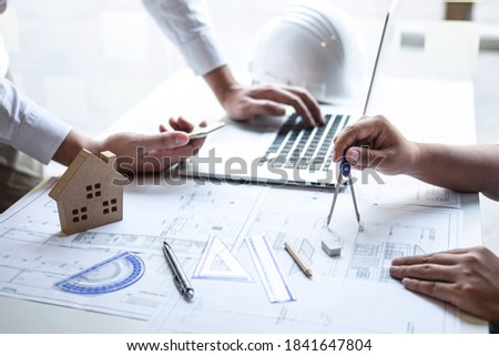 Team of construction engineering or architect partner discuss a blueprint while checking information on drawing and sketching meeting for architectural project with engineering equipment tool.