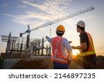 A team of construction engineers talks to managers and construction workers at the construction site. Quality inspection, work plan, home and industrial building design project