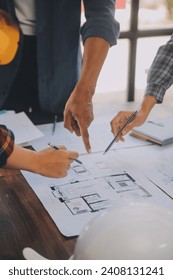 A team of construction engineers talks to managers and construction workers at the construction site. Quality inspection, work plan, home and industrial building design project
