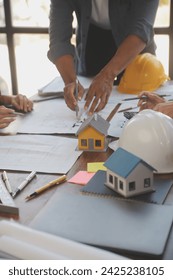 A team of construction engineers talks to managers and construction workers at the construction site. Quality inspection, work plan, home and industrial building design project