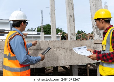 A team of construction engineers talks with managers and construction workers at the construction site. Quality inspection, plans, home and industrial building design projects