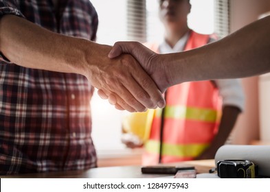 Team Of Construction Worker Shaking Hands With Customer After Finishing Up Business Meeting To Greeting Start Up Project Contract In Office Center At Construction Site, Business And Contractor Concept