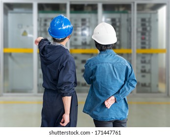 A team of construction workers with helmets at work place in a factory