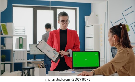 Team Of Coworkers Using Green Screen On Laptop To Work On Startup Business. Women Working With Mock Up Template And Isolated Background On Chroma Key Computer Display In Office.