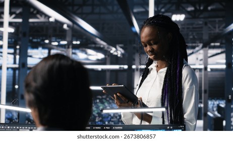 Team of data center developers doing brainstorming, monitoring neural network AI LLM. Teamworking colleagues in high tech facility oversee servers powering machine learning processes, camera A