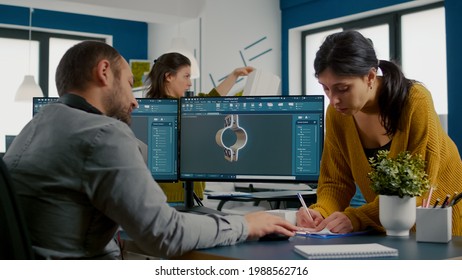 Team discussing about industrial project using dual monitors setup to desing 3D gears and metalic clamp in CAD software. Industrial engineer and african project manager working together in creative