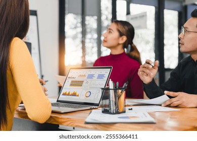 A Team discussing data analytics with laptop on table