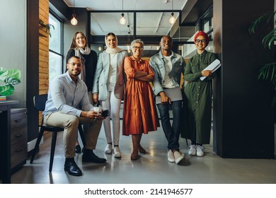 Team of diverse businesspeople smiling at the camera in a modern office. Group of multicultural entrepreneurs running a successful startup in an inclusive workplace. - Shutterstock ID 2141946577