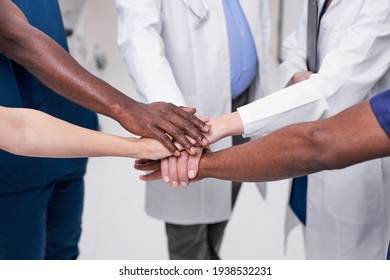 Team of diverse medical doctors putting hands together. Unity concept