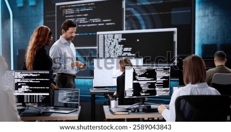 Team of diverse software engineers coding on desktop computers in office.