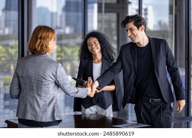 Team of diversity business people having agreement and handshake deal over new strategic strategy project on investment real estate with recognition and applause from other colleague for partnership - Powered by Shutterstock