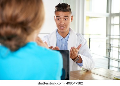 Arztteam und Krankenschwester diskutieren über eine Patientendiagnose am Schreibtisch in einem modernen, hellen Büro