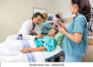 Team of doctor and nurses examining patient in hospital