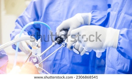 Team of doctor or surgeon in blue gown inside operating room in hospital.Surgeon did laparoscopic or endoscopic knee or shoulder orthopedic surgery.Endoscopy of thyroid surgery with light effect.