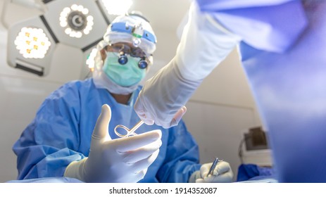 Team Of Doctor Working Inside Modern Operating Room.Scrub Nurse Sending Surgical Scissors To Surgeon.Focus At Instrument With Intention To Blurred Background.Advanced Cardiac Surgery Procedure.