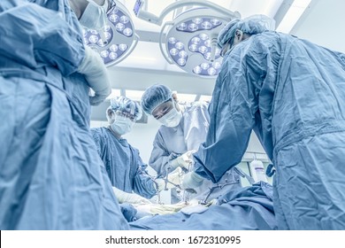 Team of doctor working inside operating room. Surgeon performed total knee replacement surgery in uprisen angle. Medical concept.