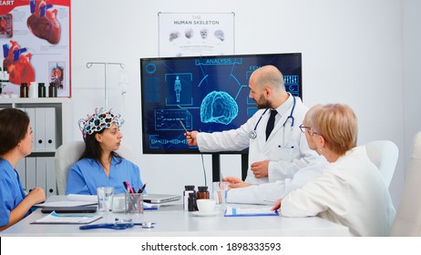 Team Of Doctors Analysing Brain Functions Using High Tech In Medical Conference Room, Assistant Testing New Innovation. Medic Studying Diagnosis For Treatment Of Patients Working In Hospital Boardroom