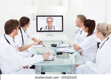 Team of doctors attending video conference at desk in hospital
