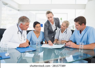 Team of doctors and businesswoman having a meeting in medical office