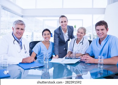 Team of doctors and businesswoman having a meeting in medical office - Powered by Shutterstock