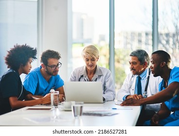 Team of doctors in a meeting planning and brainstorming in a boardroom using a laptop to read notes. Group of healthcare professionals discussing and talking in a modern office - Powered by Shutterstock