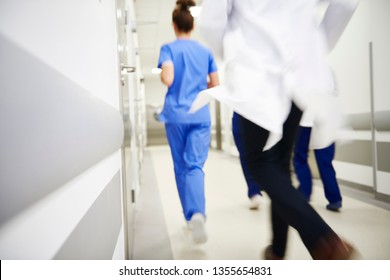 Team of doctors running in a hurry. Focus on the wall - Powered by Shutterstock