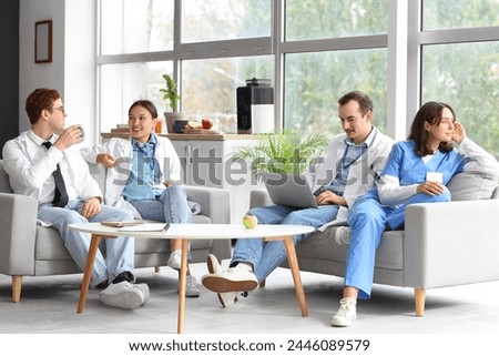 Team of doctors sitting on sofas in hospital rest room