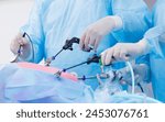 Team doctors use medical instrument for laparoscopic cholecystectomy stomach, operating room hospital. Closeup surgeon hold surgical equipment in minimal invasive endoscopic surgery, blue light.