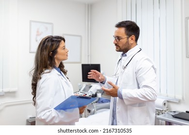 Team of doctors working together on patients file at hospital. Medical staff analyzing report and working at clinic. Woman doctor having discussion in a hospital with colleague - Powered by Shutterstock