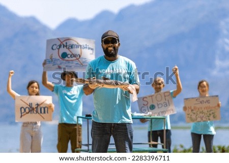 Team of ecologist volunteers are demonstrating rally at ocean for climate change and saving nature concept with protest sign against pollution and sea contamination for wildlife and biodiversity